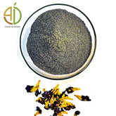Butterfly pea powder in a glass bowl with dried butterfly pea flowers