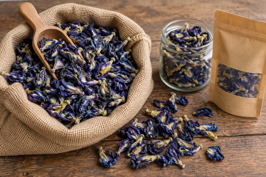 Dried aparajita (butterfly pea) flowers in a bulk jute sack beside a small retail pack